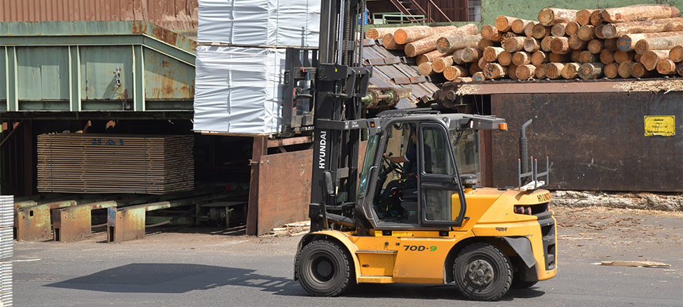 Hyundai 70D-9 chargé de lourdes grumes pour la construction, en route pour le point de chargement HGV