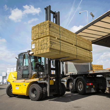 Bediener eines Hyundai-Diesel-Gabelstaplers 50d-9 beim Heben von Holz außerhalb des seitlichen Sichtfeldes