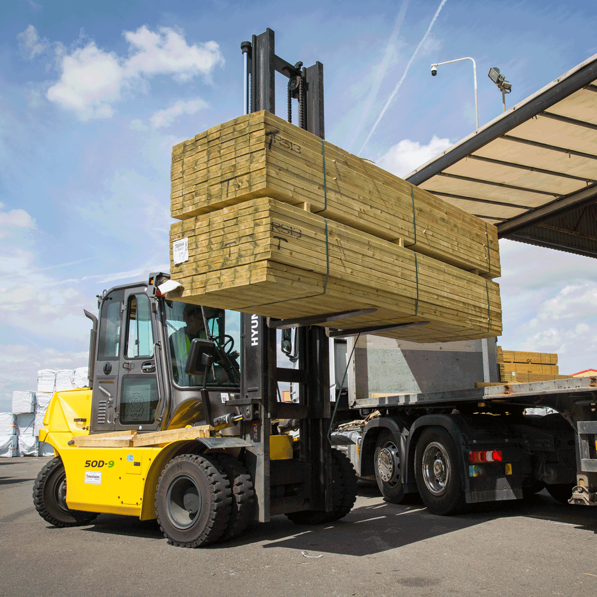 Hyundai 50d-9 diesel forklift operator lifting timber outside side view
