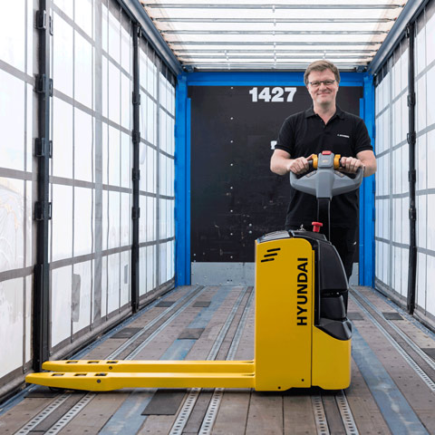 hyundai 18ep pallet truck side view with operator